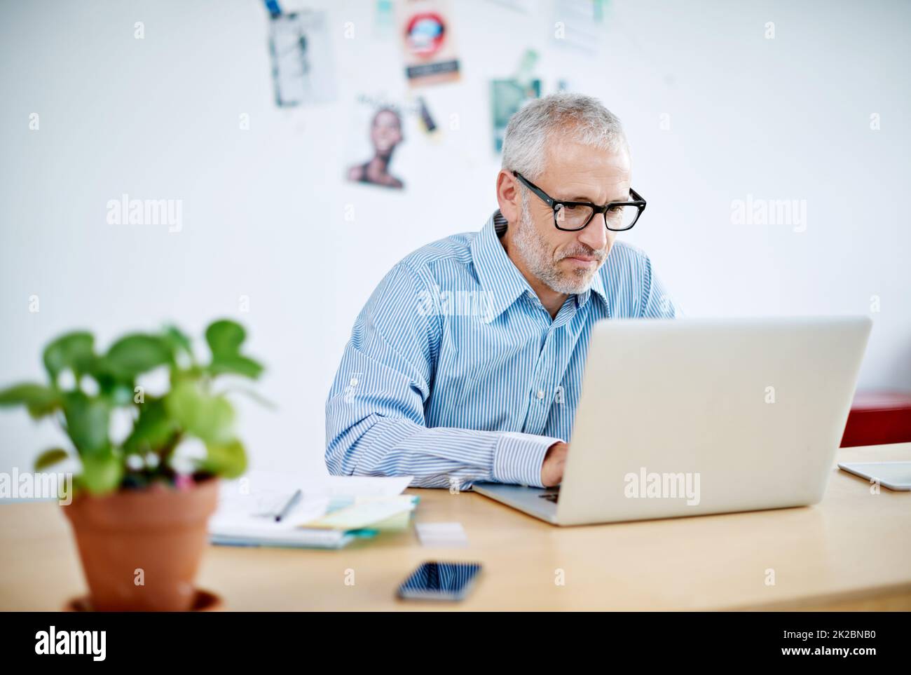 Photo d'un homme d'affaires charmant travaillant sur son ordinateur portable. Les dessins commerciaux affichés dans cette image représentent une simulation d'un vrai produit et ont été modifiés ou modifiés assez par notre équipe de spécialistes de la retouche et de la conception pour qu'ils soient libres de Banque D'Images