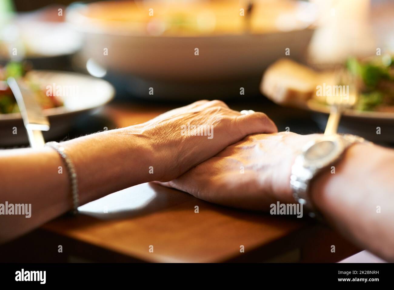 Nous nous sommes mutuellement. Plan court d'un couple tenant les mains dans la prière à la table avant de manger. Banque D'Images
