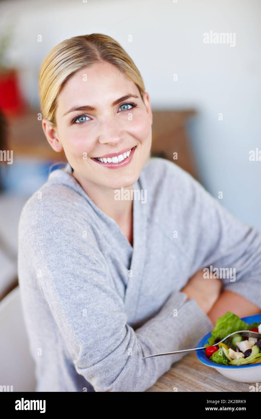 Manger propre et rester en bonne santé. Prise de vue d'une belle jeune femme en appréciant une salade saine à la maison. Banque D'Images