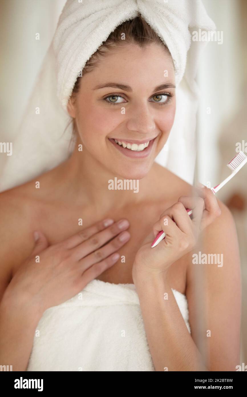Se sentir positif au sujet de l'hygiène dentaire. Une jeune femme attirante se brossant les dents. Banque D'Images