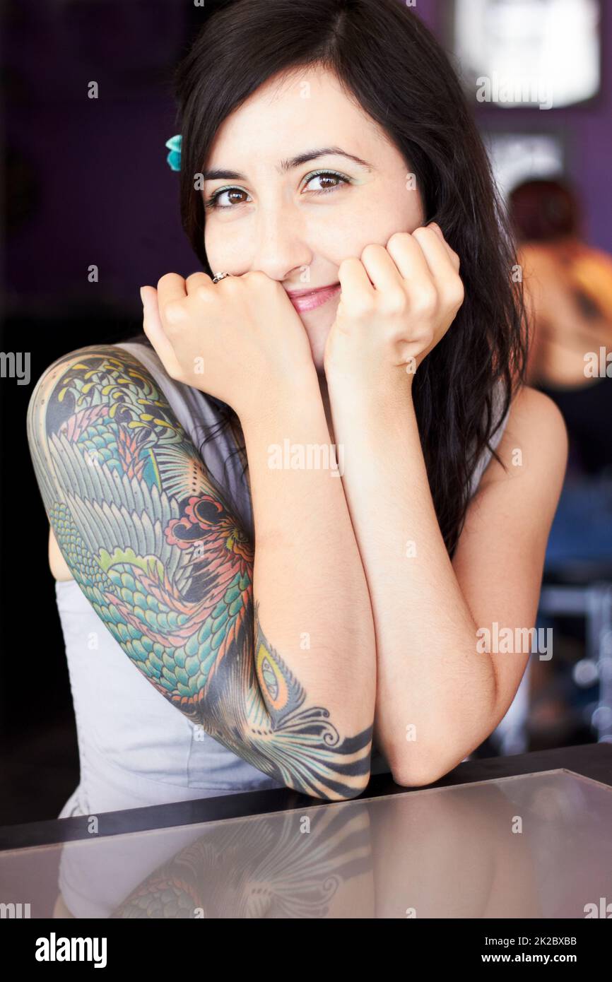 Présentation de son style individuel. Portrait d'une artiste de tatouage féminine montrant son tatouage à demi-manche. Banque D'Images