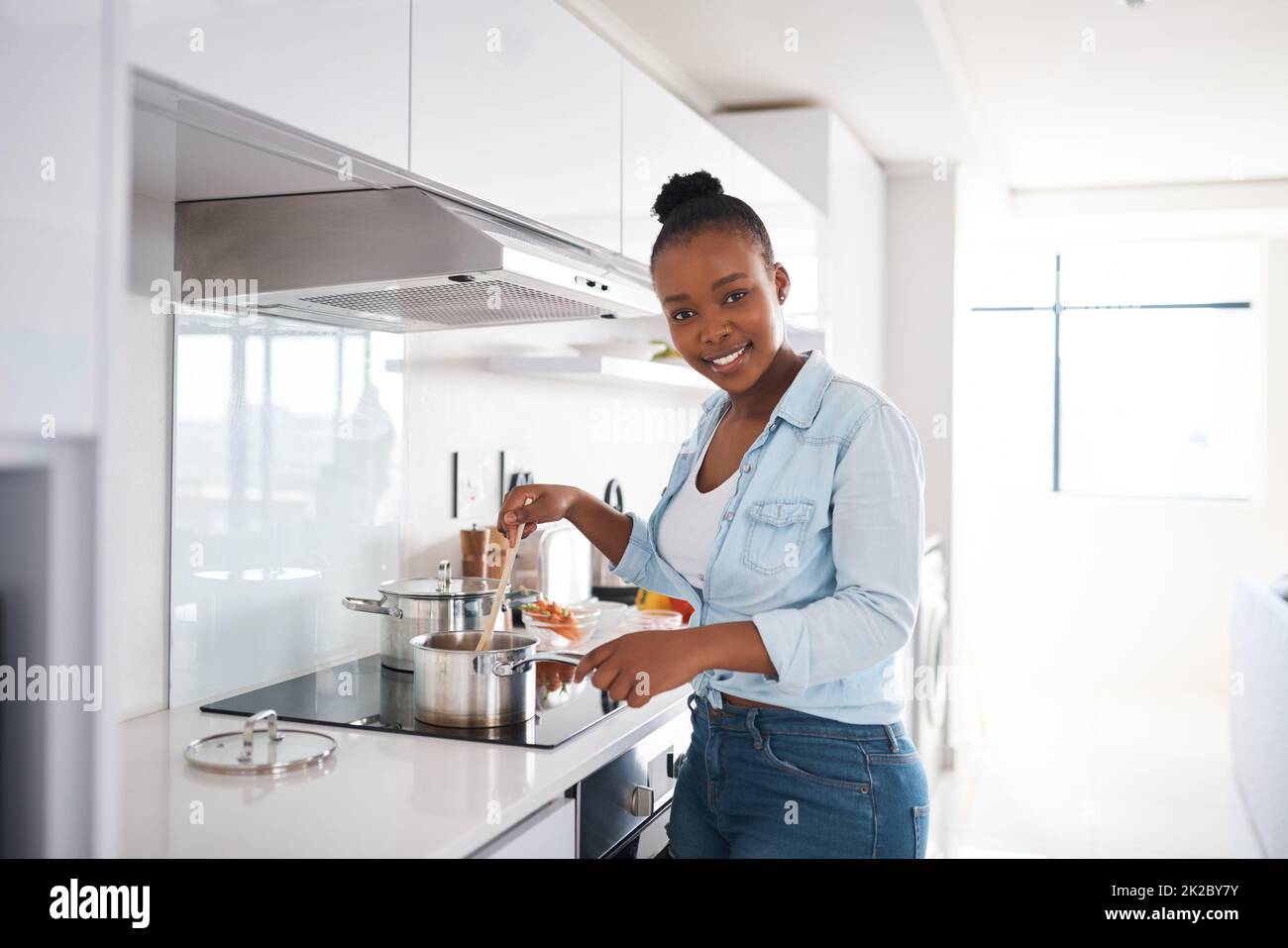 Un repas copieux est ce qui fait d'une maison une maison. Photo d'une belle jeune femme qui cuisine dans sa cuisine à la maison. Banque D'Images