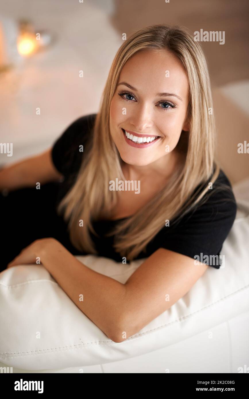 Prendre le temps pour moi. Portrait d'une jeune femme blonde assise sur son canapé à la maison. Banque D'Images