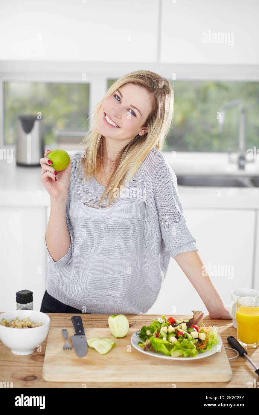 Rien de mieux que manger bien et se sentir super. Bonne jeune femme qui fait des choix alimentaires sains à la maison. Banque D'Images