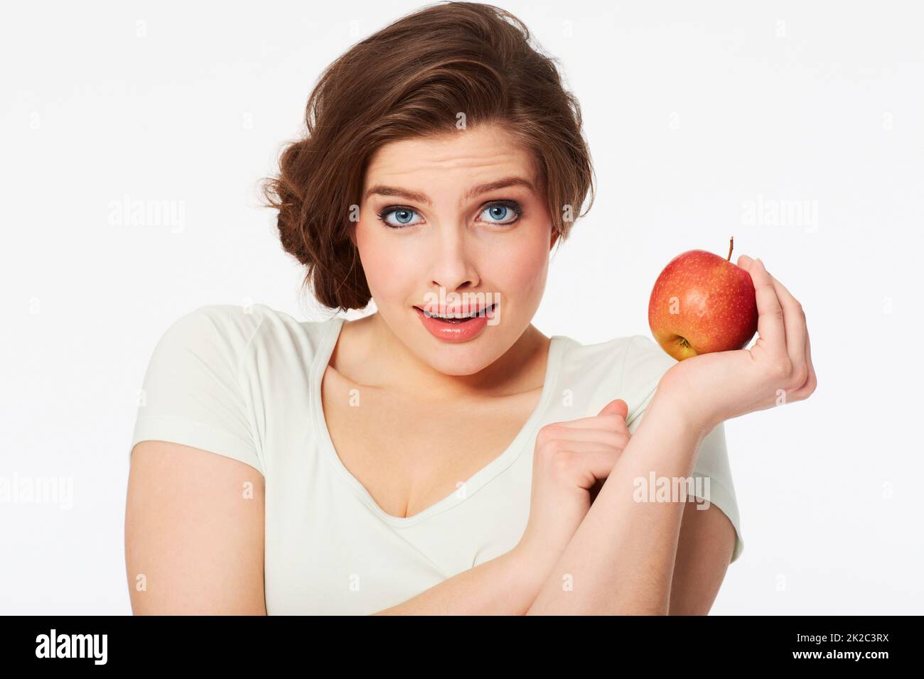 Le choix sain. Portrait d'une jolie femme brune tenant une pomme rouge. Banque D'Images