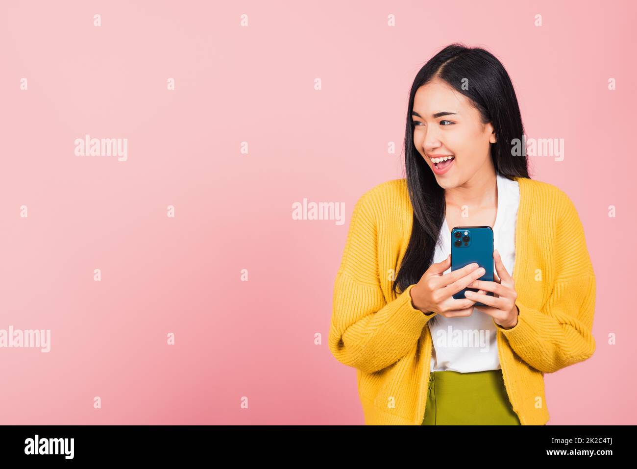 femme adolescente souriante enthousiaste à l'aide d'un téléphone portable intelligent Banque D'Images