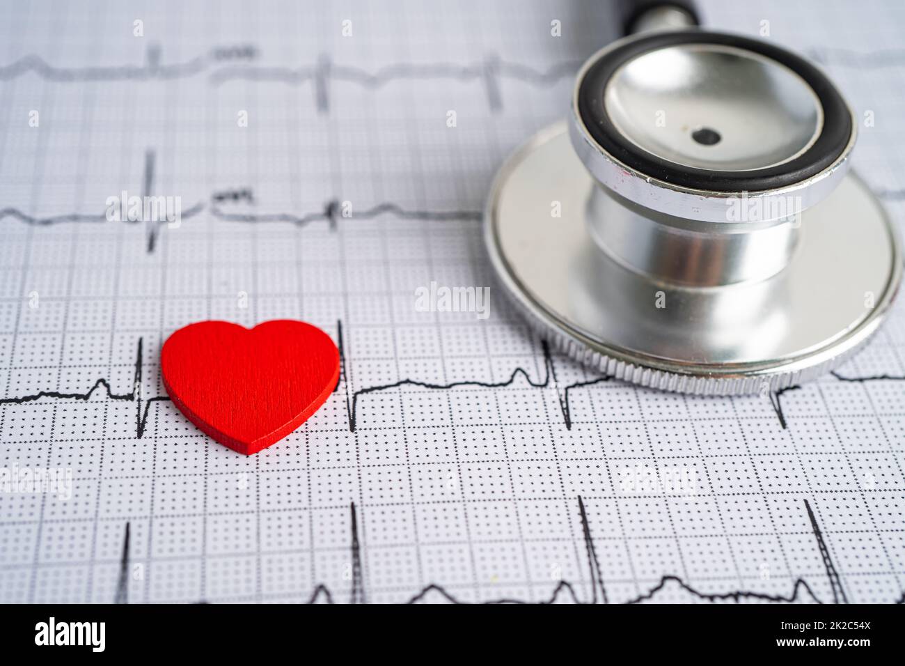 Stéthoscope sur ECG d'électrocardiogramme avec cœur rouge, onde cardiaque, crise cardiaque, rapport de cardiogramme. Banque D'Images