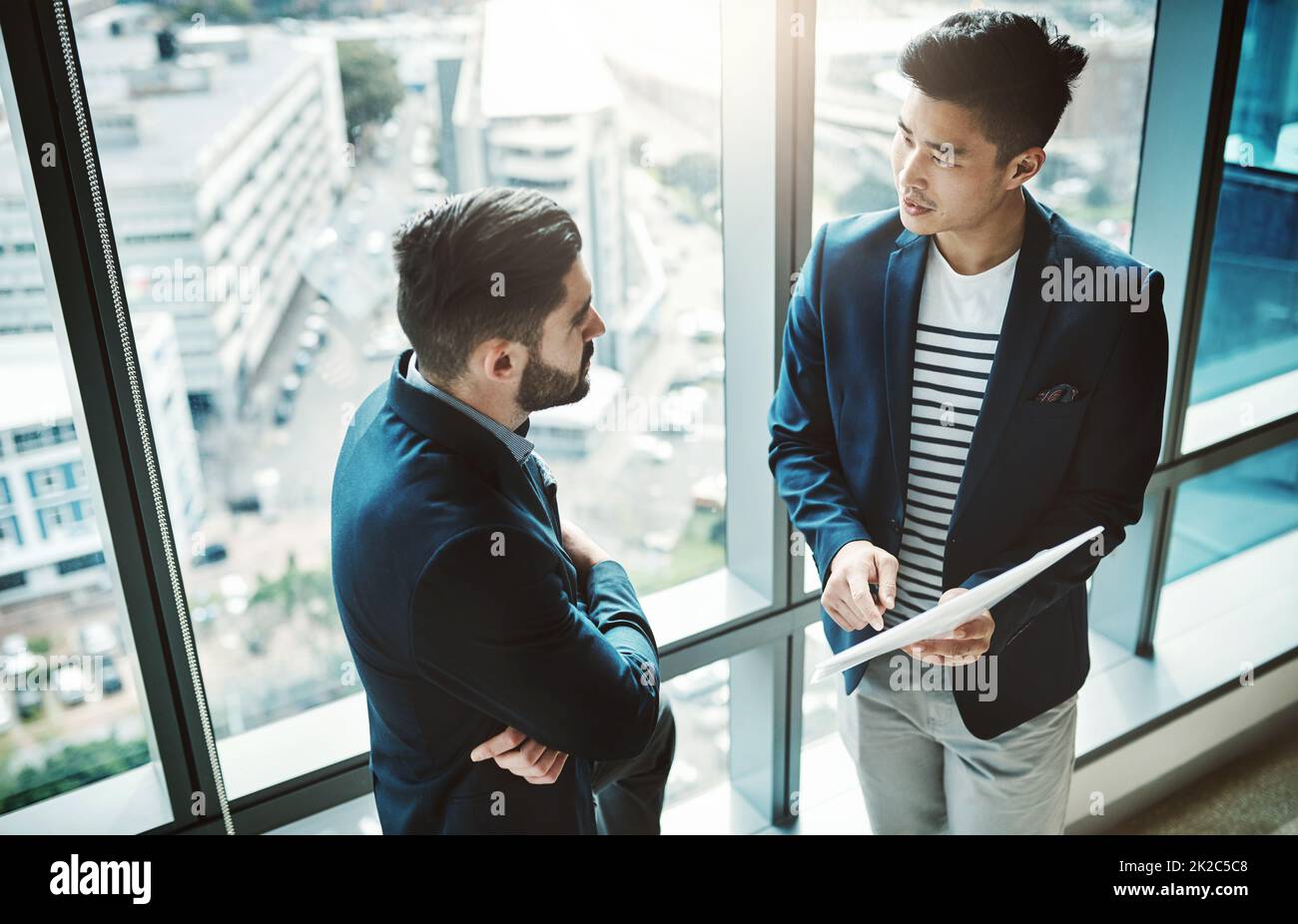 Voir, les données ne se trouvent pas. Photo de deux jeunes hommes d'affaires discutant de la paperasse dans un bureau moderne. Banque D'Images