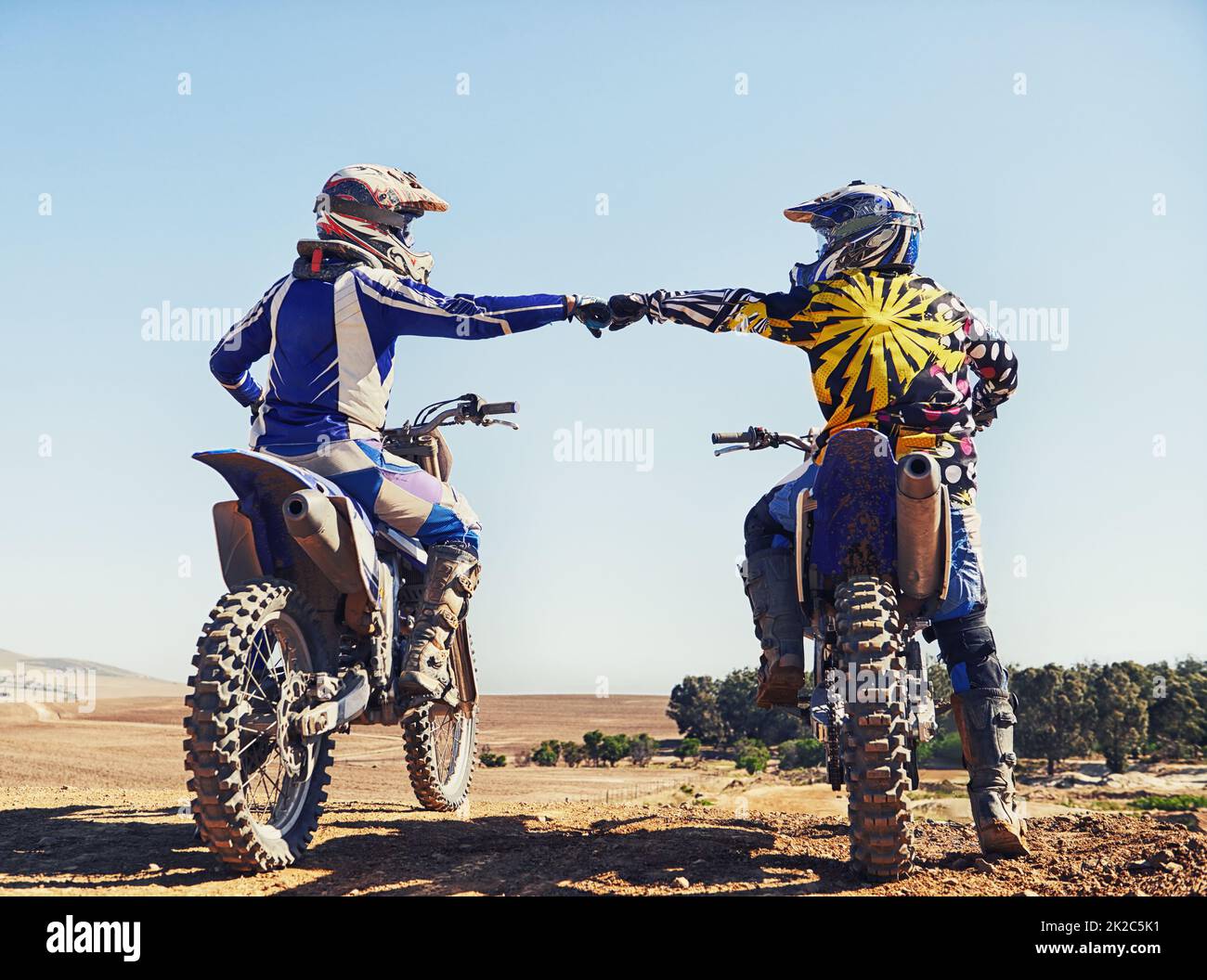 Il est temps d'extraire cette piste. Deux motocross motards qui se cognent les poings avant une course. Banque D'Images