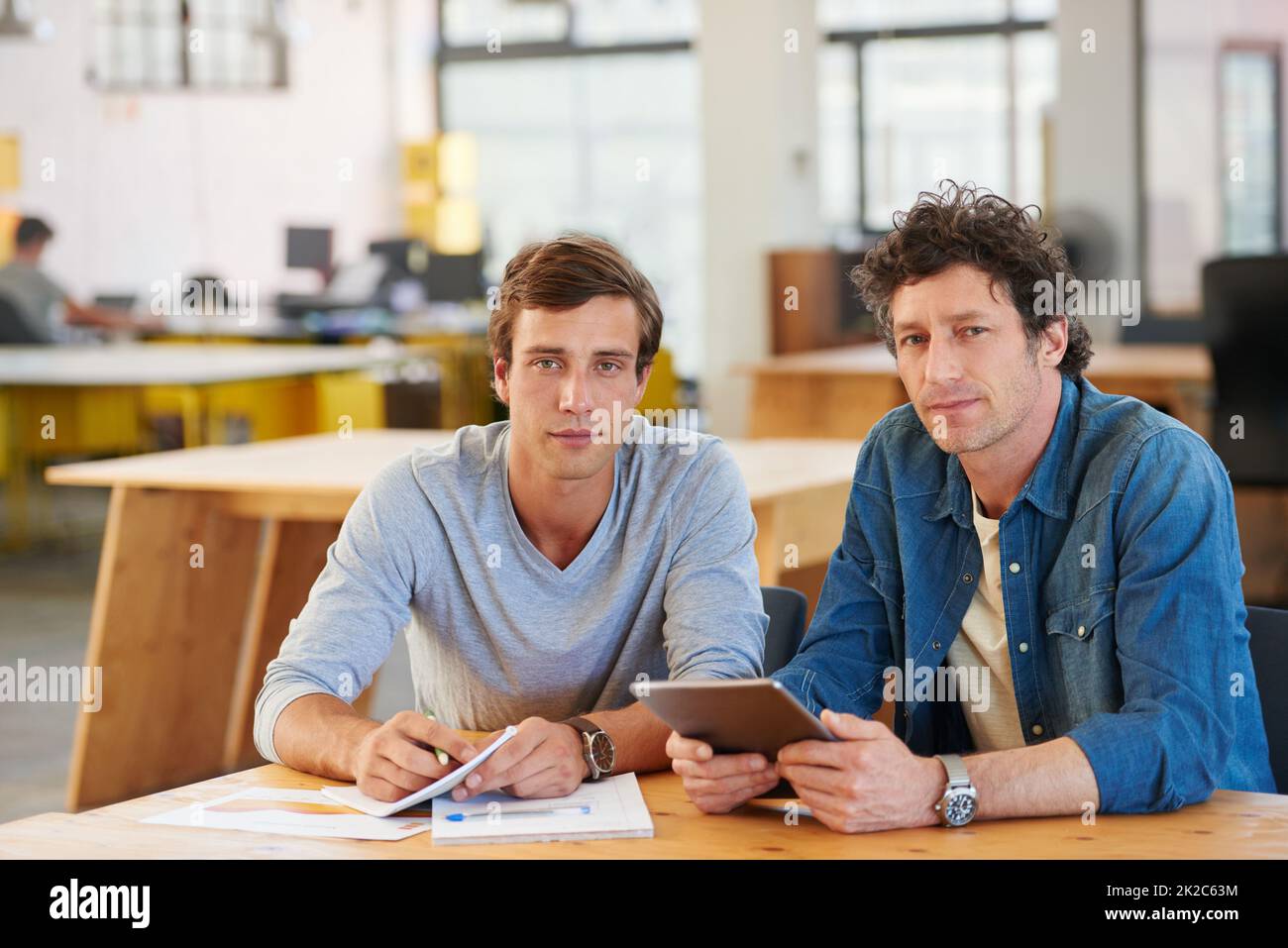 Partenaires en conception. Prise de vue de deux collègues utilisant une tablette numérique dans un bureau. Banque D'Images