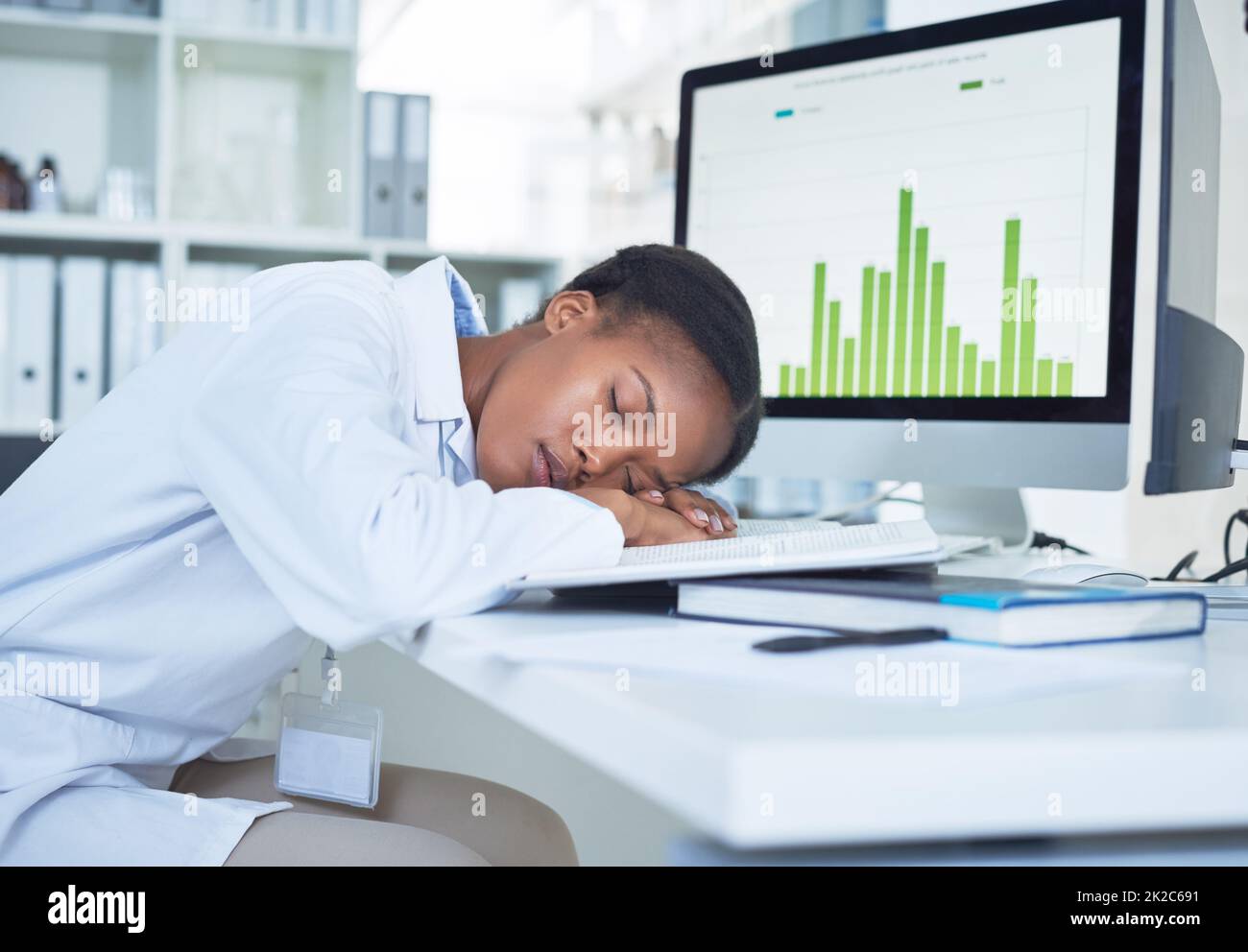Combattre l'épuisement professionnel est la moitié de la bataille. Photo d'un jeune scientifique dormant à son bureau tout en effectuant des recherches dans un laboratoire. Banque D'Images
