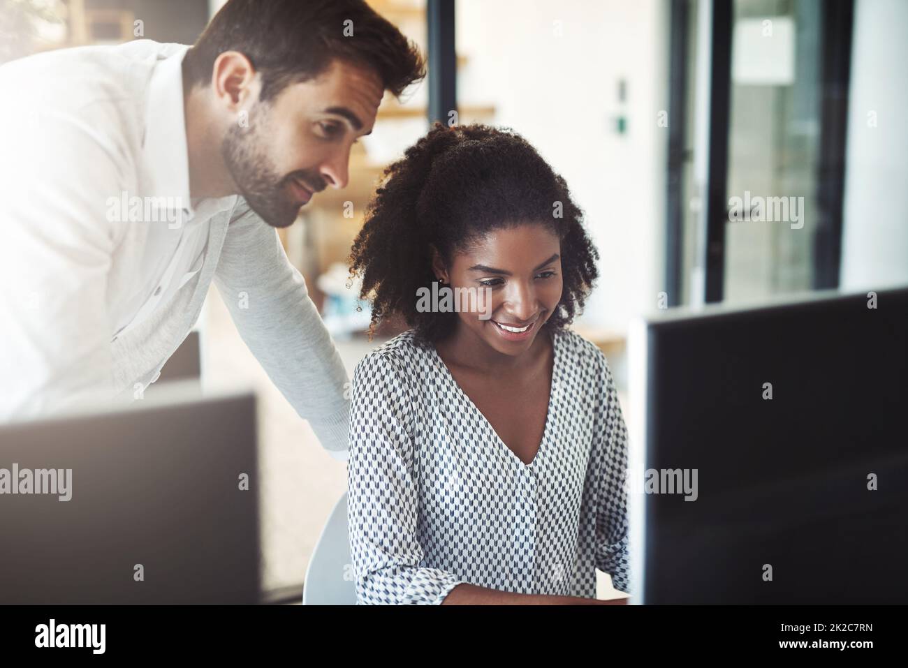 Il semble toujours avoir les réponses. Photo d'un homme d'affaires aidant son collègue à son bureau. Banque D'Images