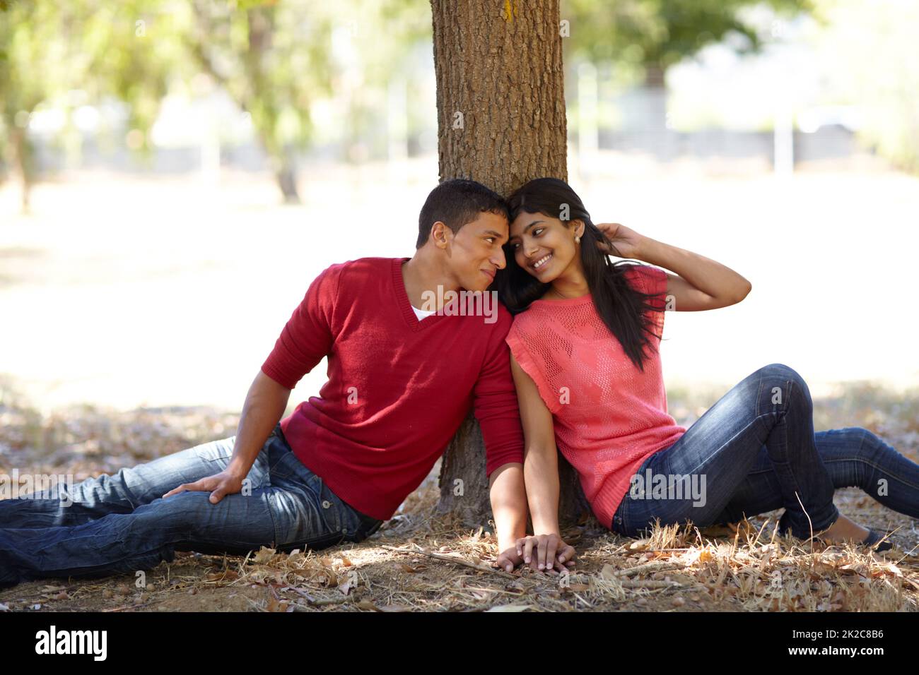 Jeune amour. Photo d'un jeune couple affectueux assis ensemble sous un arbre dans le parc. Banque D'Images