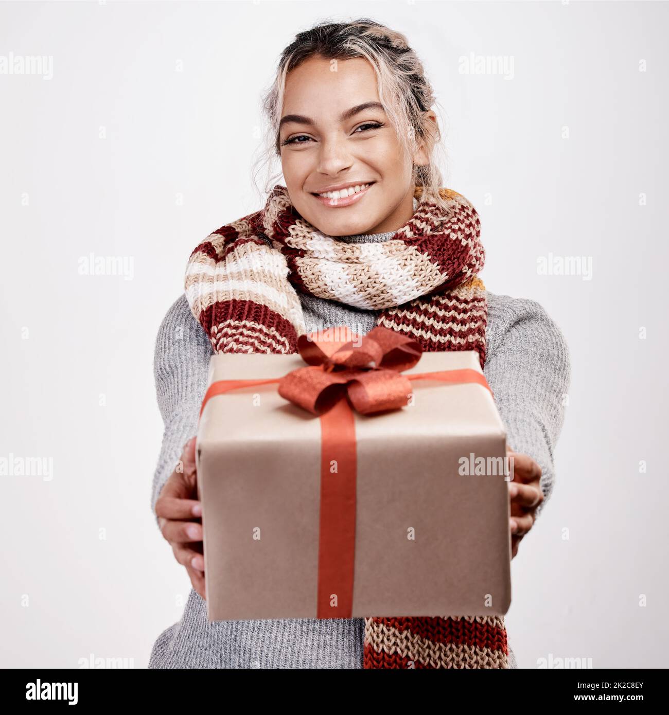 De moi à vous. Portrait studio d'une jeune femme attirante qui vous offre un cadeau tout en étant vêtue d'une tenue sur le thème de Noël. Banque D'Images