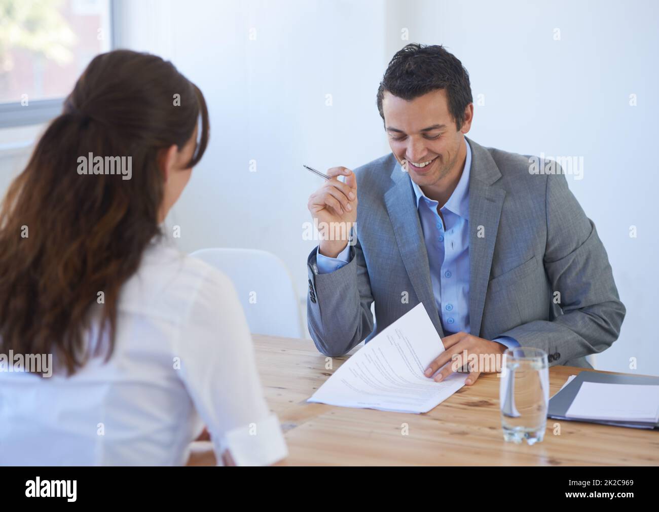 C'est excellent. Un jeune homme d'affaires qui va au-dessus d'un candidat reprend impressionnant lors d'une entrevue d'emploi. Banque D'Images