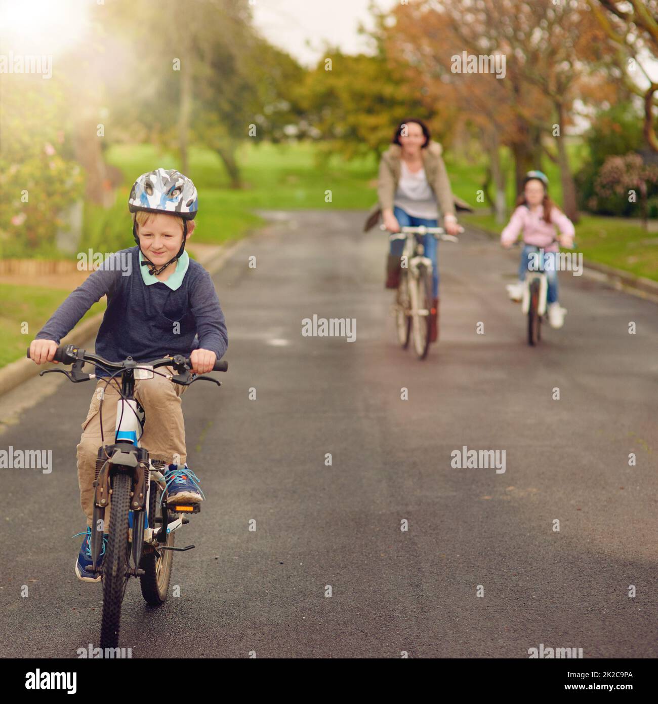C'est une belle journée pour une balade à vélo. Prise de vue d'une mère et de ses deux jeunes enfants à vélo à l'extérieur. Banque D'Images