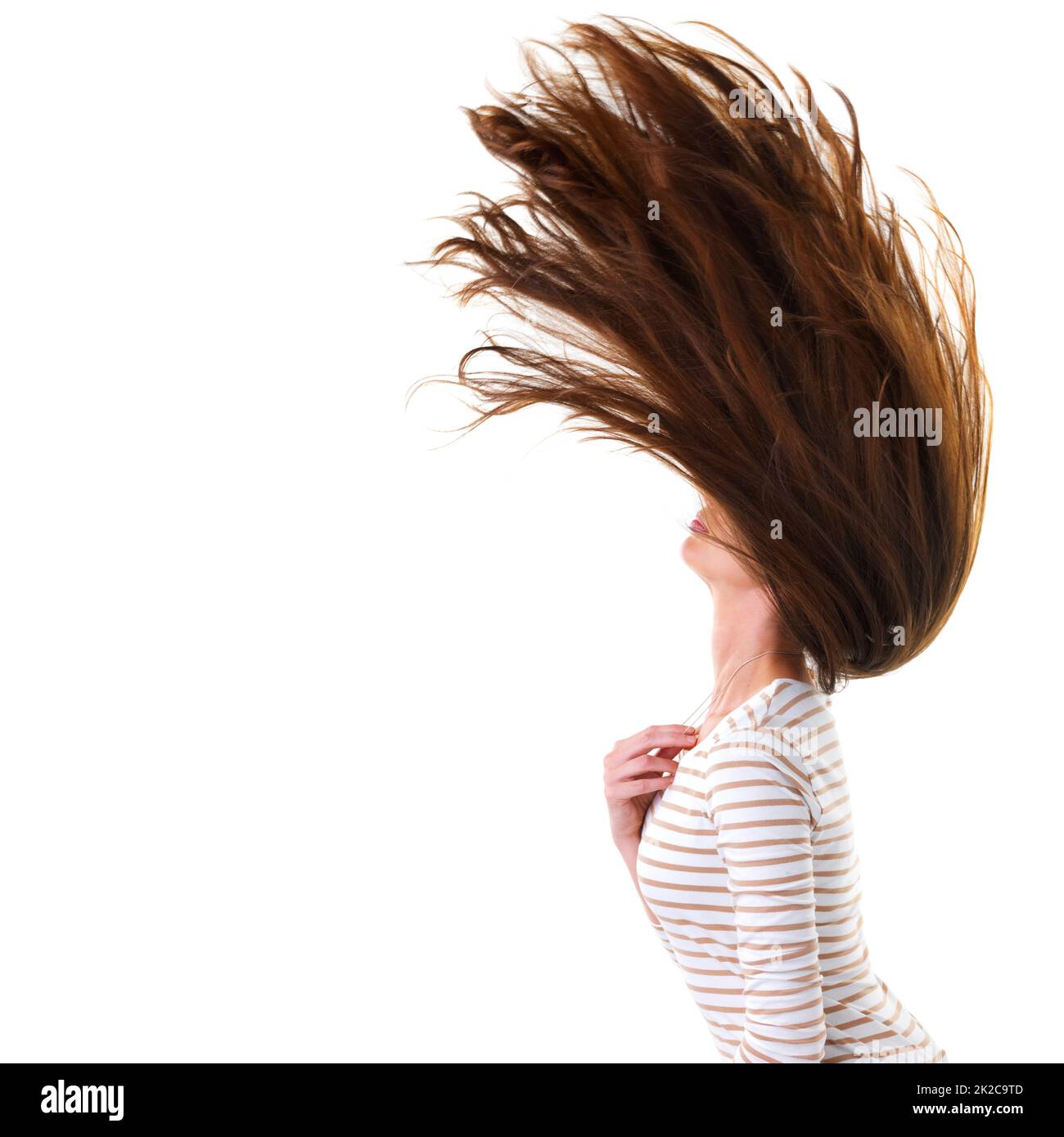 Balancer ses cheveux. Photo en studio d'une jeune femme attirante tortillant ses cheveux isolés sur blanc. Banque D'Images