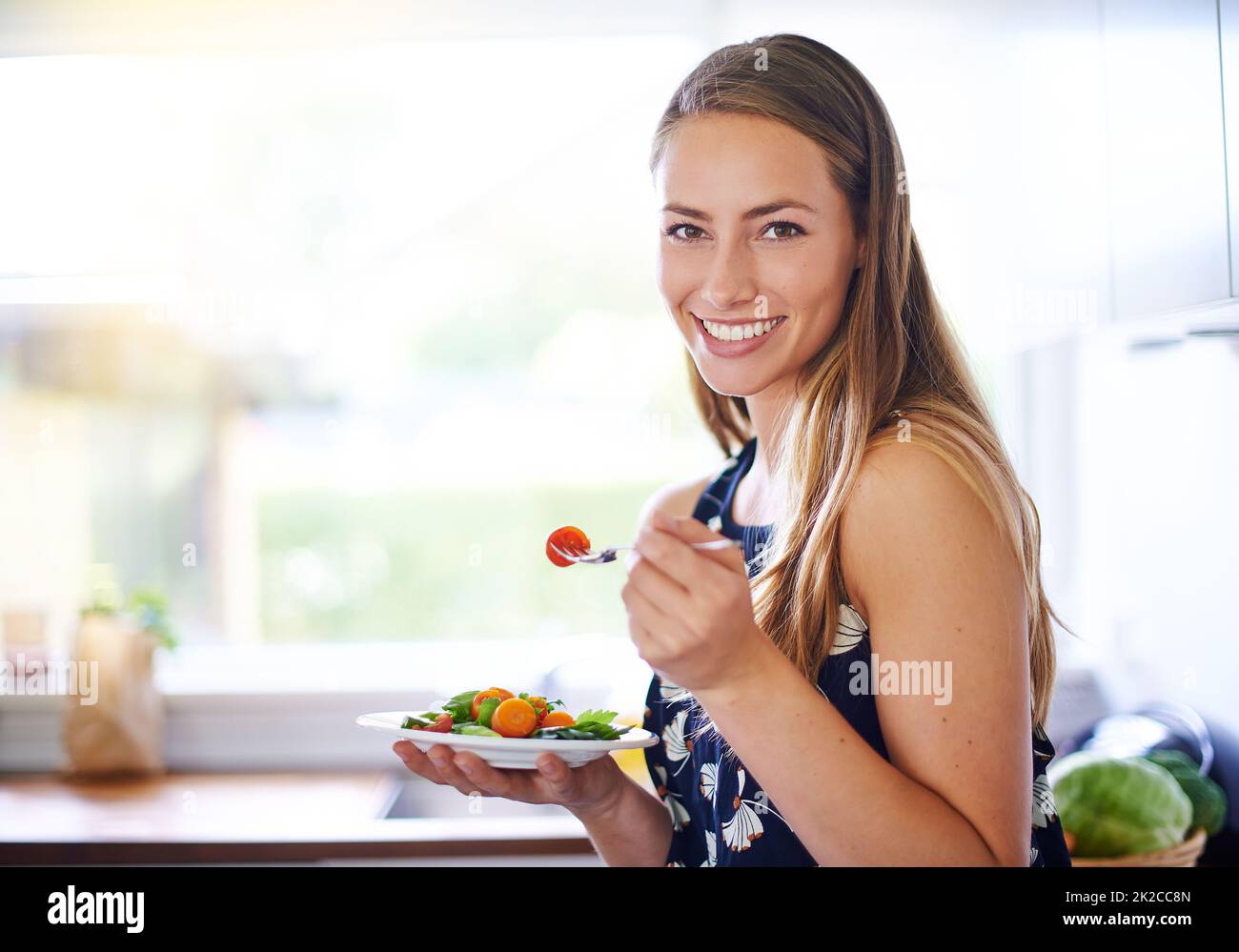 Manger sainement pour vivre en bonne santé. Portrait d'une jeune femme mangeant un bol de fraises à la maison. Banque D'Images