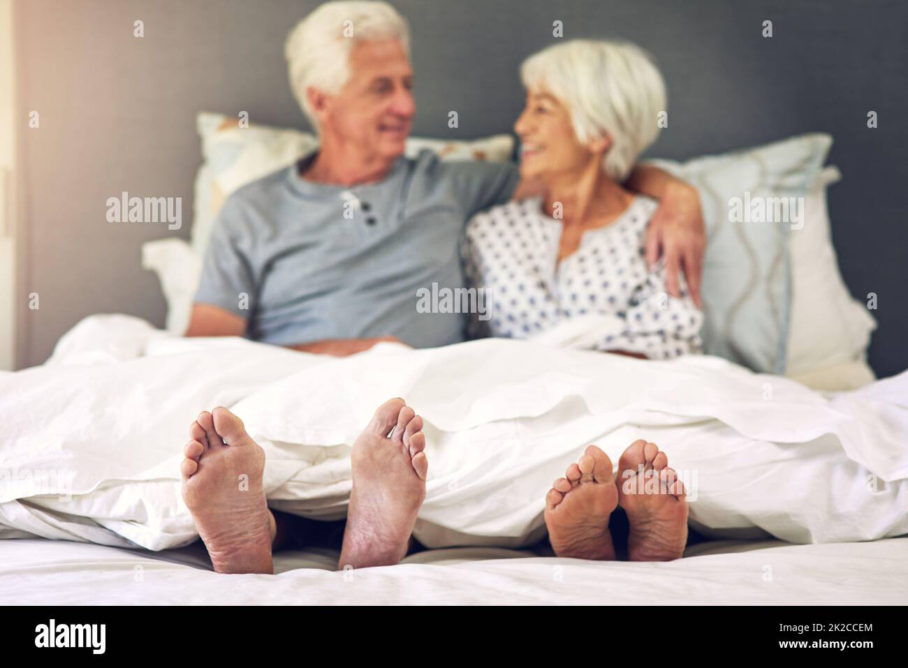 Se réveiller à côté de vous est inestimable. Photo d'un couple senior allongé dans le lit. Banque D'Images