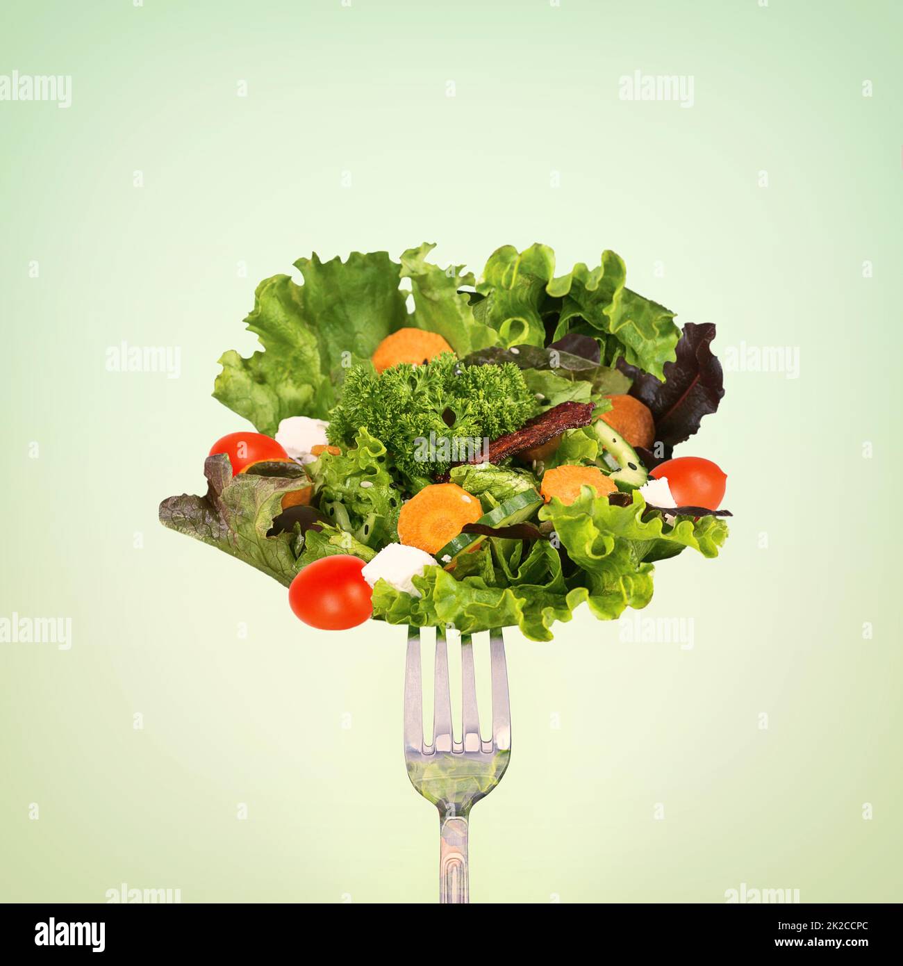 Mangez sainement. Un panier de salade sur fond vert. Banque D'Images