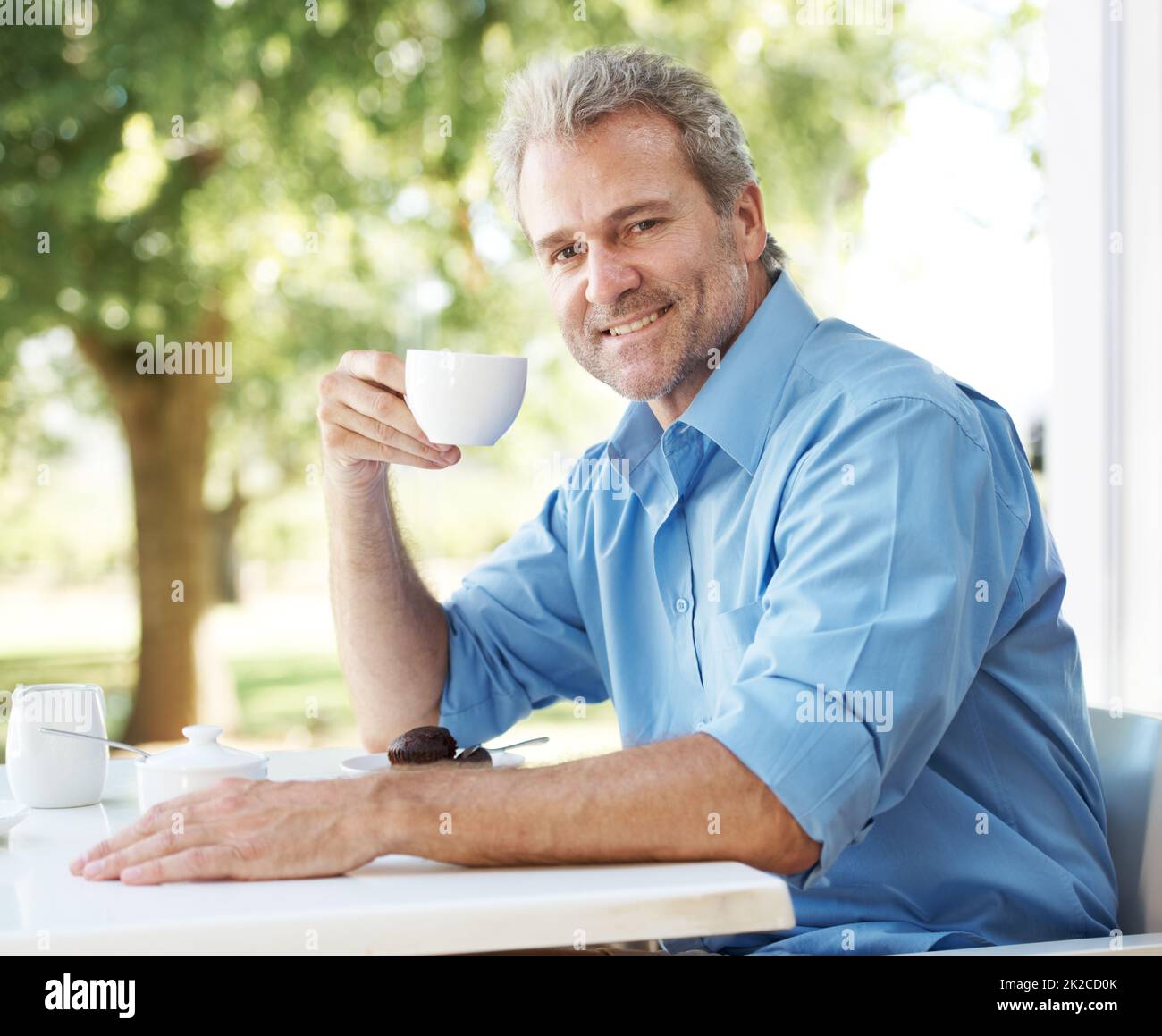 Se détendre avec son café quotidien. Heureux homme mature qui apprécie une tasse de café à l'extérieur. Banque D'Images