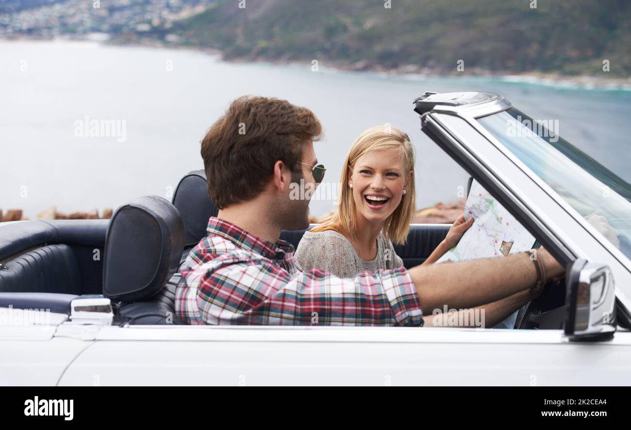 Allons au volant. Photo d'un jeune couple en train de profiter d'un trajet le long de la côte dans un cabriolet. Banque D'Images