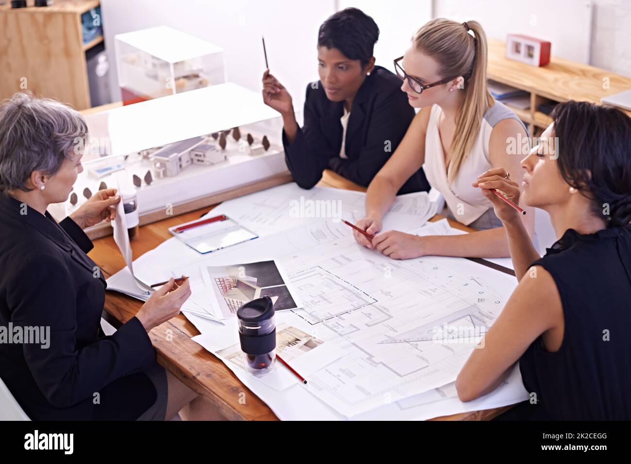 Rencontre des esprits. Un groupe d'architectes féminins travaillant ensemble sur un projet à une table de conférence. Banque D'Images