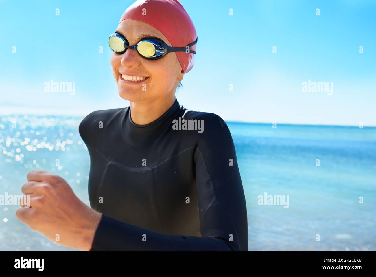 L'entraînement pour sauver des vies. Une jeune femme s'entraîne sur la plage en hiver dans une combinaison et un équipement de natation complets. Banque D'Images