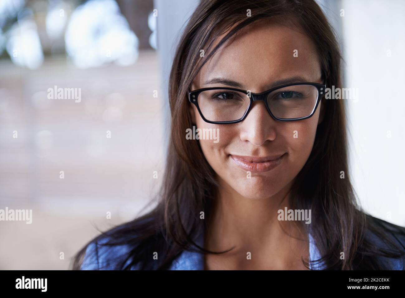 Axée sur sa carrière. Portrait d'une jeune femme d'affaires réussie debout près d'une fenêtre. Banque D'Images