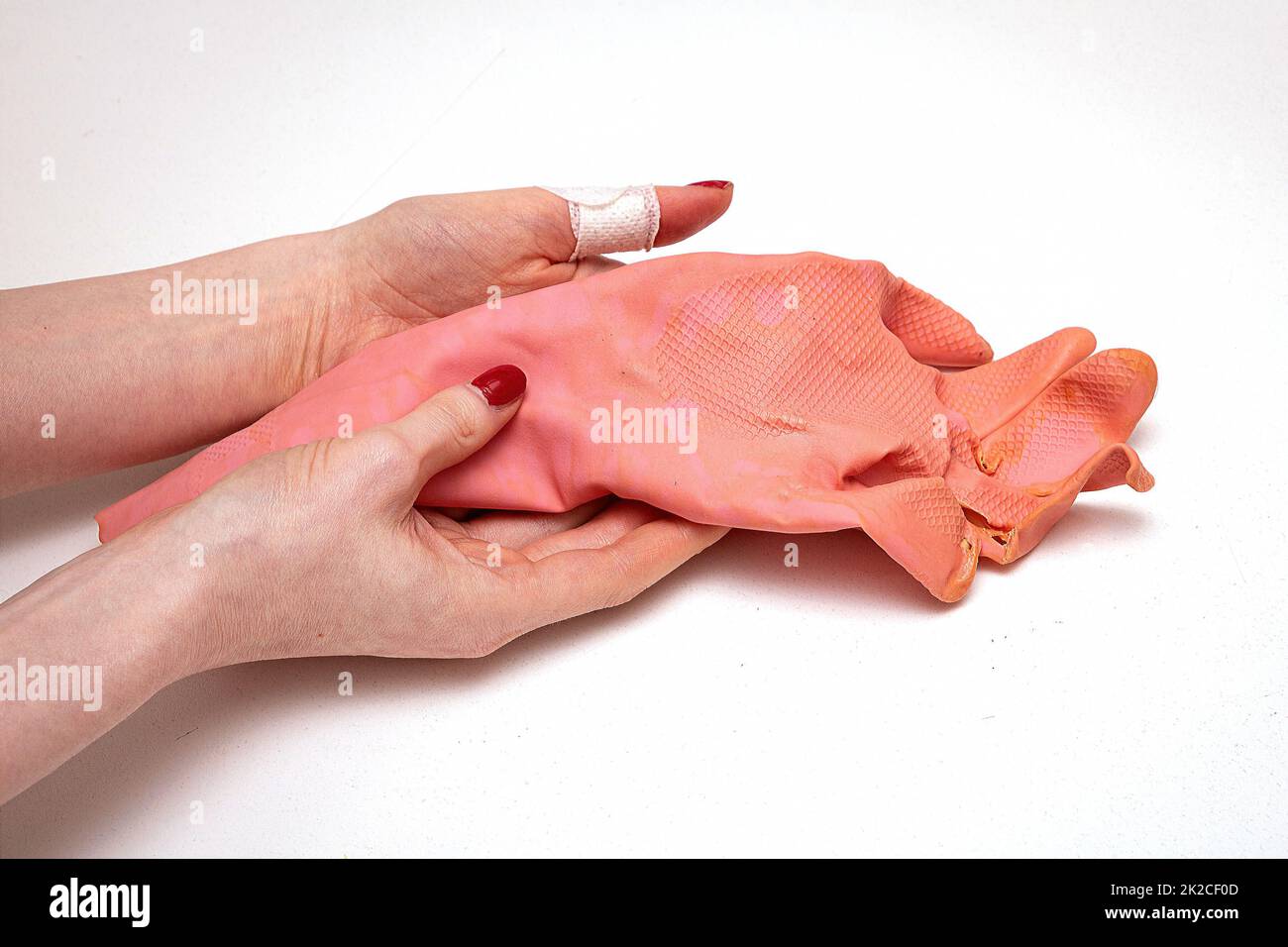 Gants de lavage abîmés dans les mains de la femme Banque D'Images