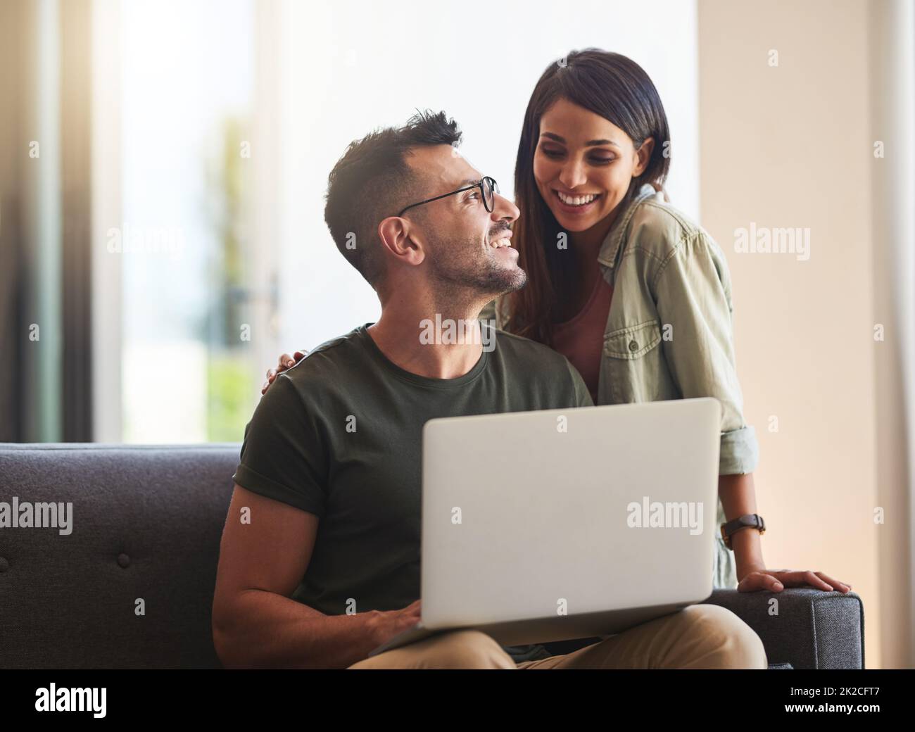 Réservez en ligne pour les vacances que nous avons toujours voulu. Photo d'un jeune couple utilisant un ordinateur portable à la maison. Banque D'Images
