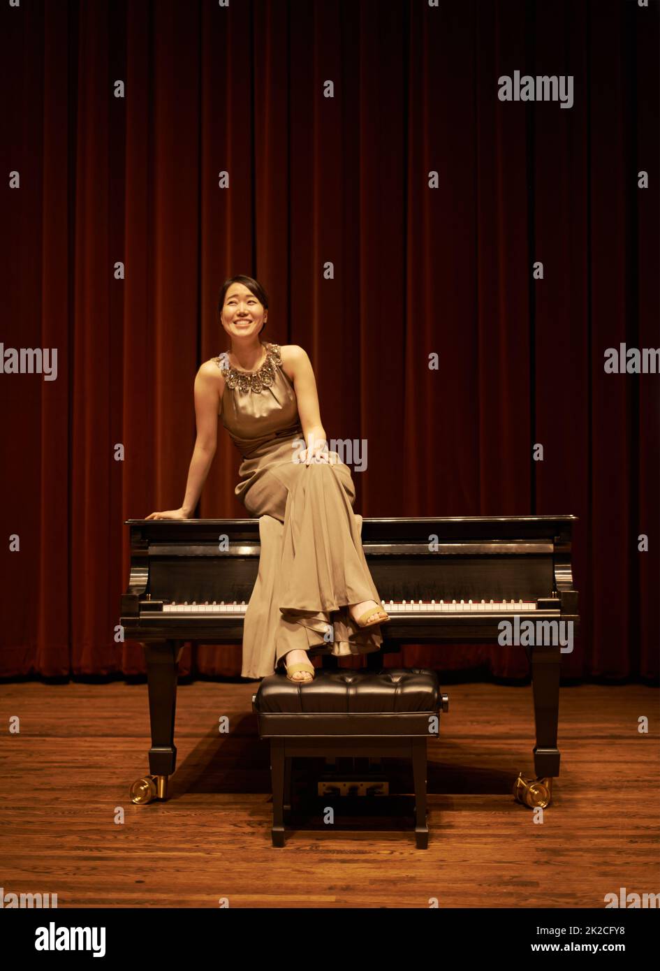 Des shes prêts à plaire à la foule. Prise de vue d'une jeune femme assise sur son piano à la fin d'un concert musical. Banque D'Images