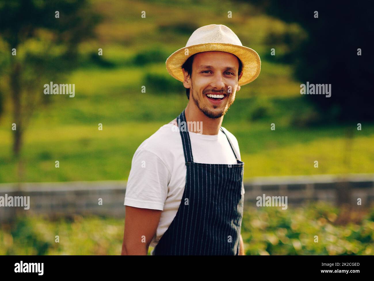 C'est une journée formidable quand vous sortez dans le jardin. Portrait d'un beau jeune homme travaillant dans un jardin. Banque D'Images