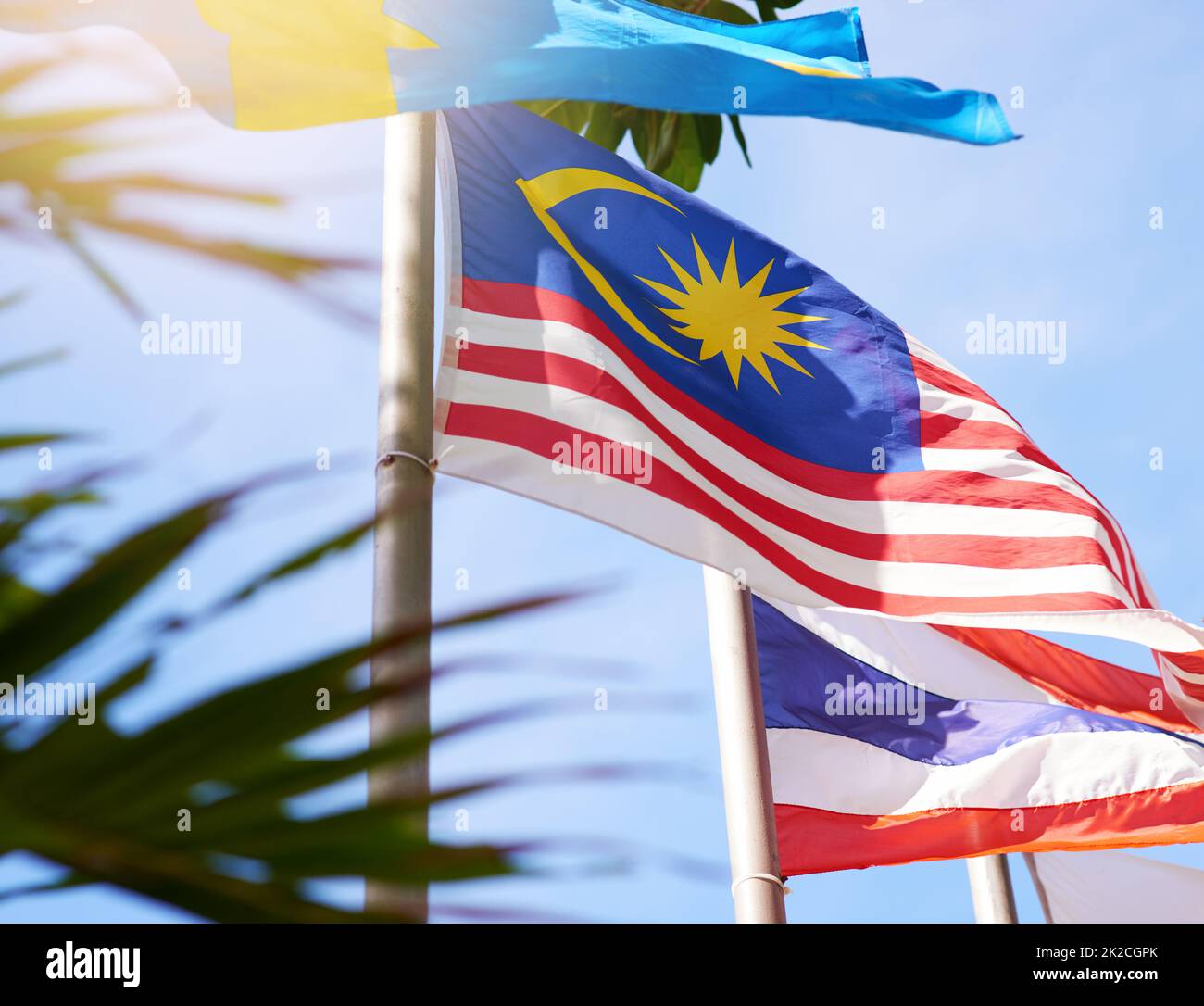 Envolez-vous haut, envolez-vous avec fierté. Photo d'un drapeau malaisien et thaïlandais soufflant dans le vent. Banque D'Images