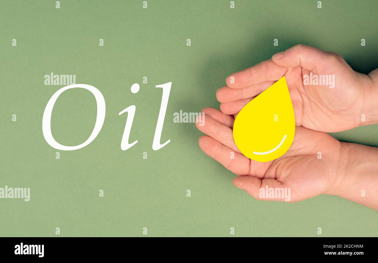 Tenir une goutte jaune, symbole du pétrole, l'augmentation des prix provoquée par le boycott, l'inflation, les énergies renouvelables Banque D'Images