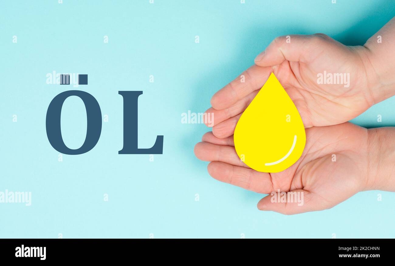 Tenir une goutte jaune, symbole du pétrole, l'augmentation des prix provoquée par le boycott, l'inflation, les énergies renouvelables Banque D'Images