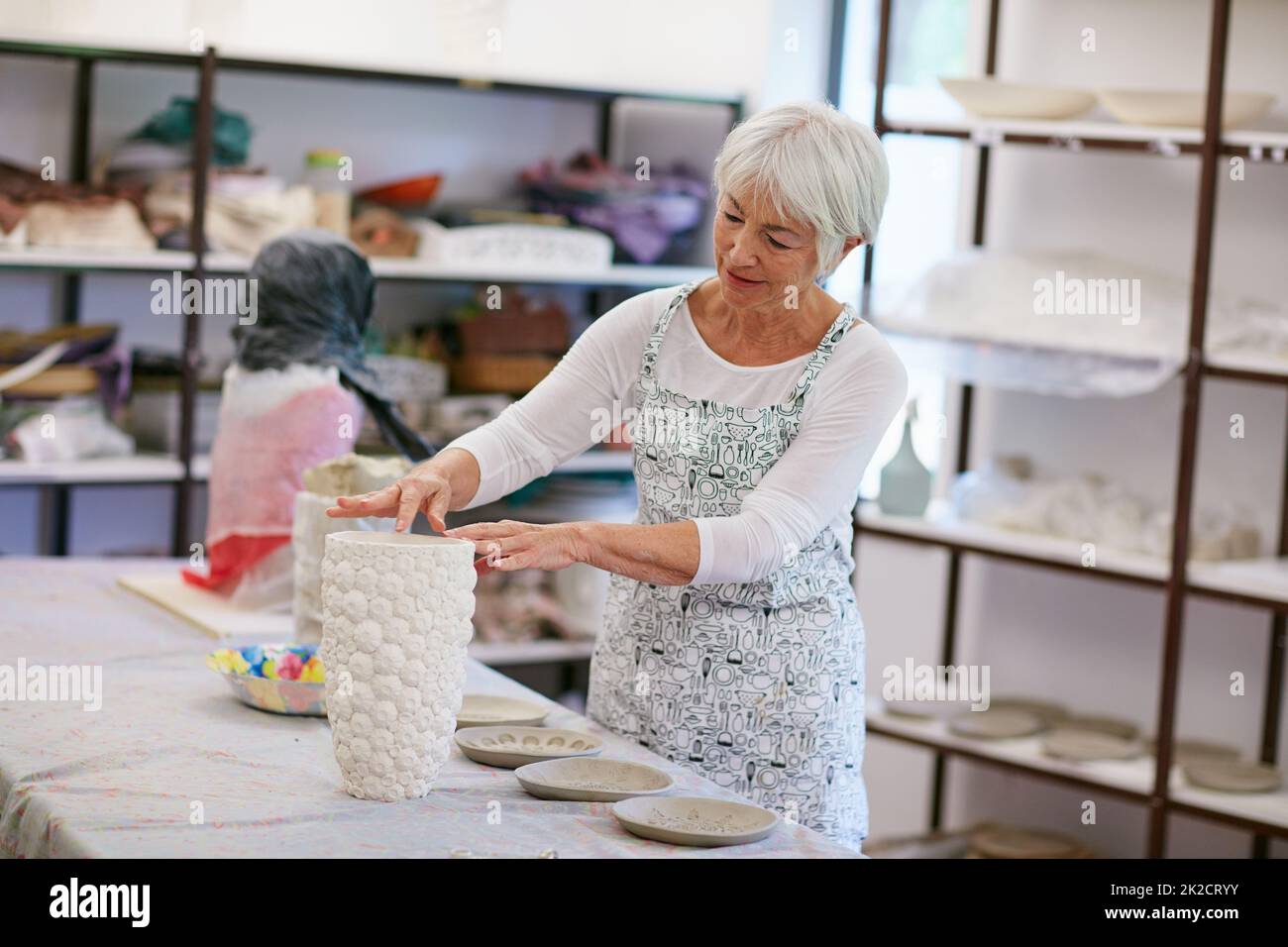 La créativité est intemporelle. Photo d'une femme âgée qui fait un pot en céramique dans un atelier. Banque D'Images