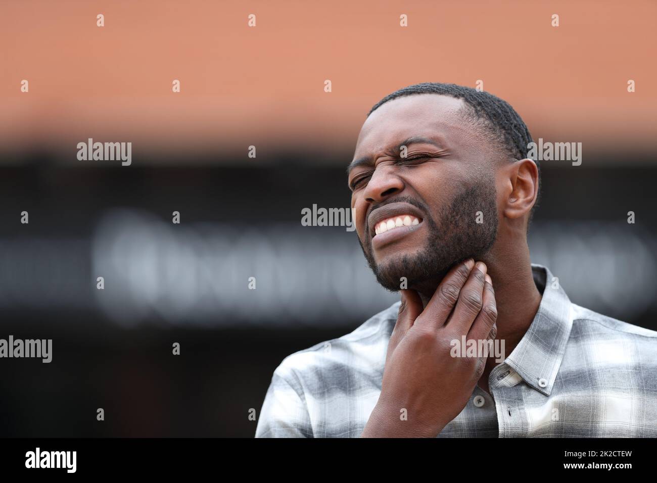 Homme à peau noire souffrant de mal de gorge dans la rue Banque D'Images