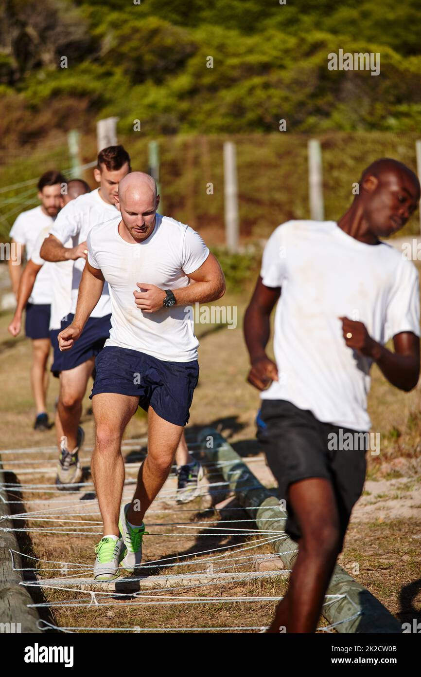 Plus dur, mieux, plus rapide, plus fort. Photo d'un groupe d'hommes effectuant des exercices dans un camp militaire. Banque D'Images