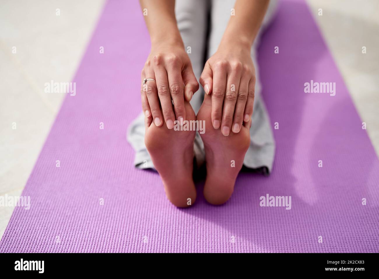 Garder la souplesse et la souplesse avec le yoga. Prise de vue d'une jeune femme qui touche ses orteils tout en pratiquant le yoga à l'extérieur par un jour ensoleillé. Banque D'Images