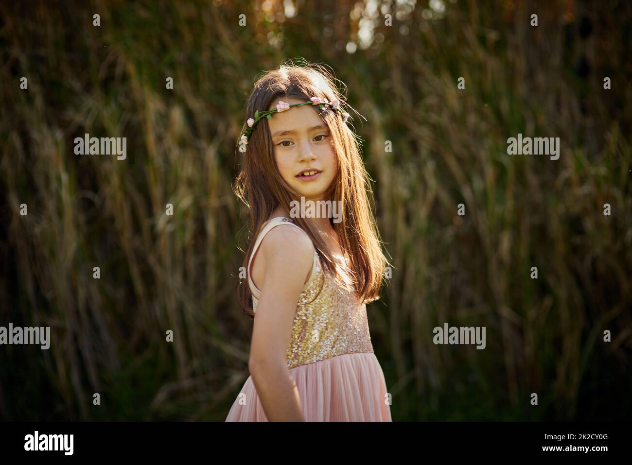 Jolie princesse. Portrait d'une petite fille mignonne dans une couronne de fleur jouant à l'extérieur. Banque D'Images