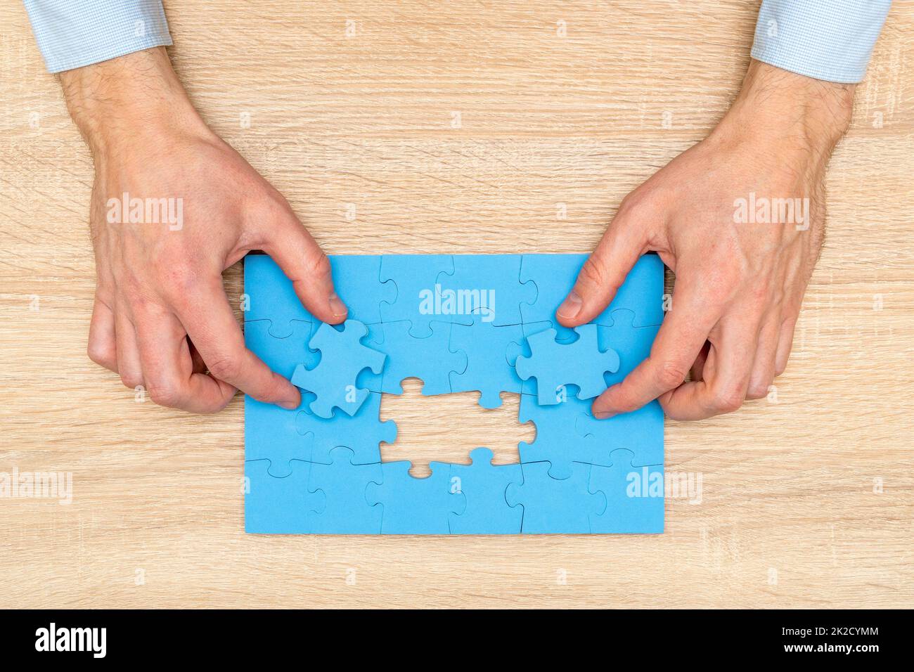 Les mains de l'homme d'affaires ont mis les dernières pièces de puzzle pour compléter la mission Banque D'Images