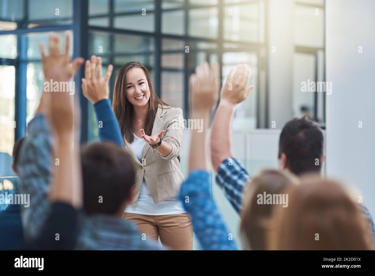 Le public a la réponse. Prise de vue d'un groupe de personnes levant la main dans un séminaire. Banque D'Images