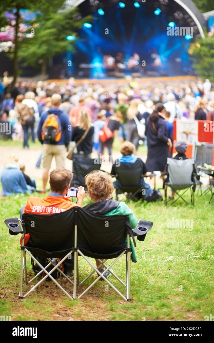 Profiter du spectacle. Vue arrière d'une foule regardant un spectacle en plein air lors d'un festival de musique. Banque D'Images