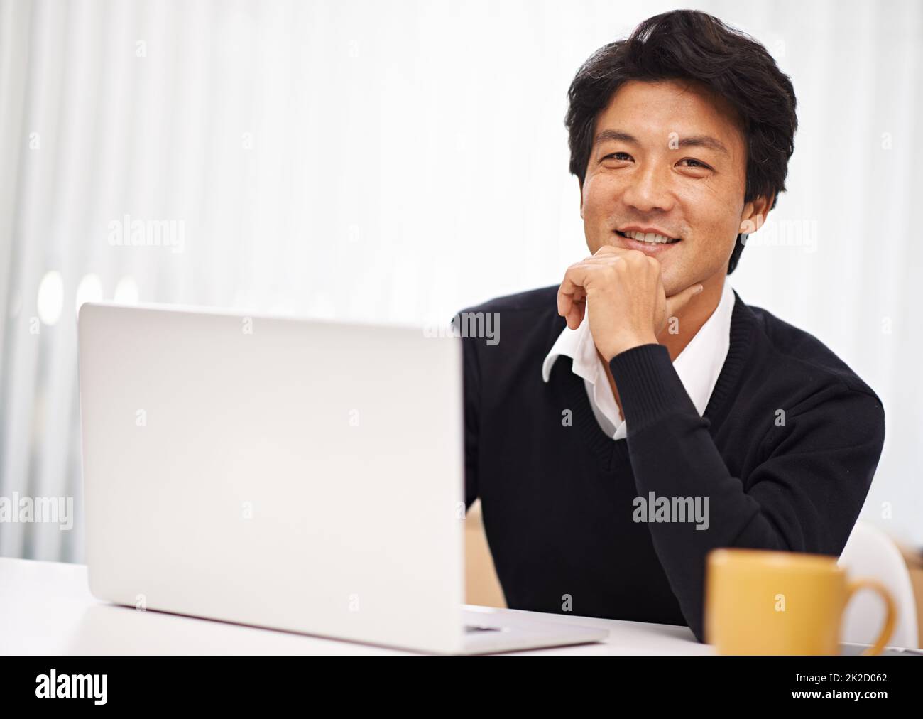 Je me sens bien aujourd'hui. Portrait d'un beau homme d'affaires asiatique travaillant à son bureau. Banque D'Images