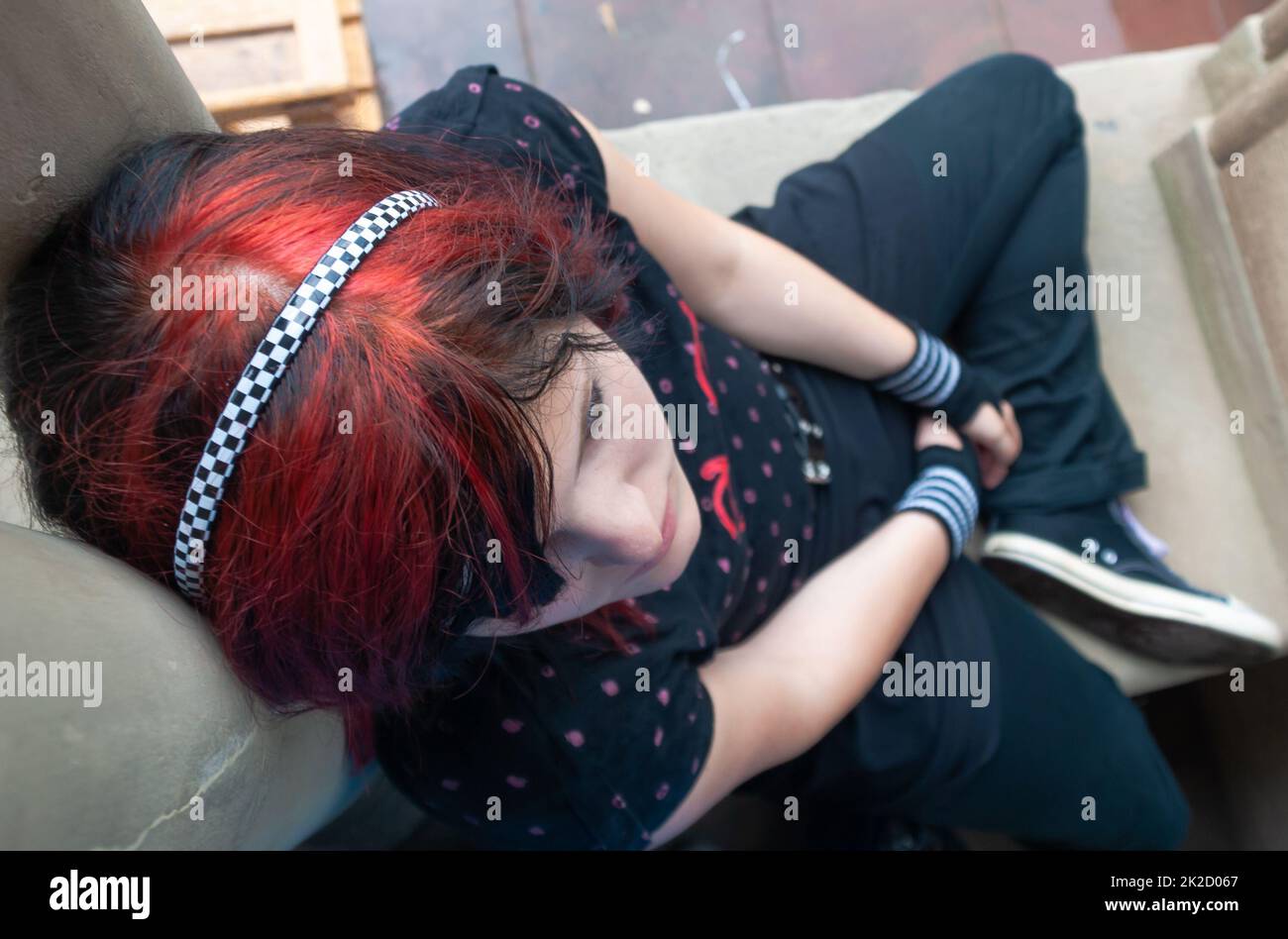 Punk emo girl, jeune adulte avec des cheveux rouges noirs Banque D'Images