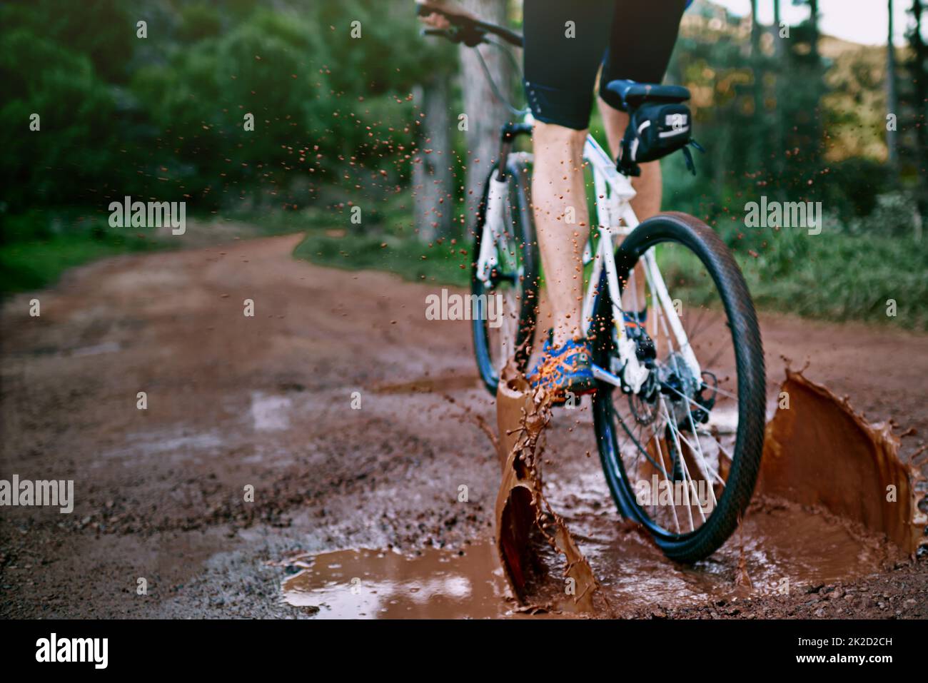 L'alimentation à travers la boue. Plan court d'un cycliste de sexe masculin sur une piste cyclable boueuse. Banque D'Images