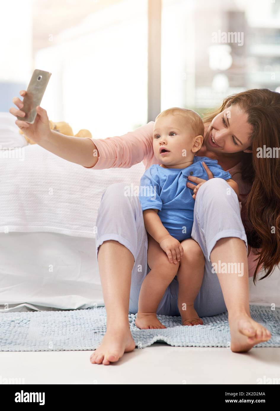 Capturer sa cutesse. Prise de vue d'une mère et de son bébé garçon en train de prendre un selfie à la maison. Banque D'Images