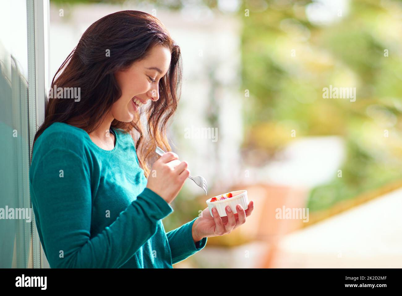 Faire le choix de manger sain chaque matin. Photo d'une jeune femme mangeant un en-cas sain à la maison. Banque D'Images