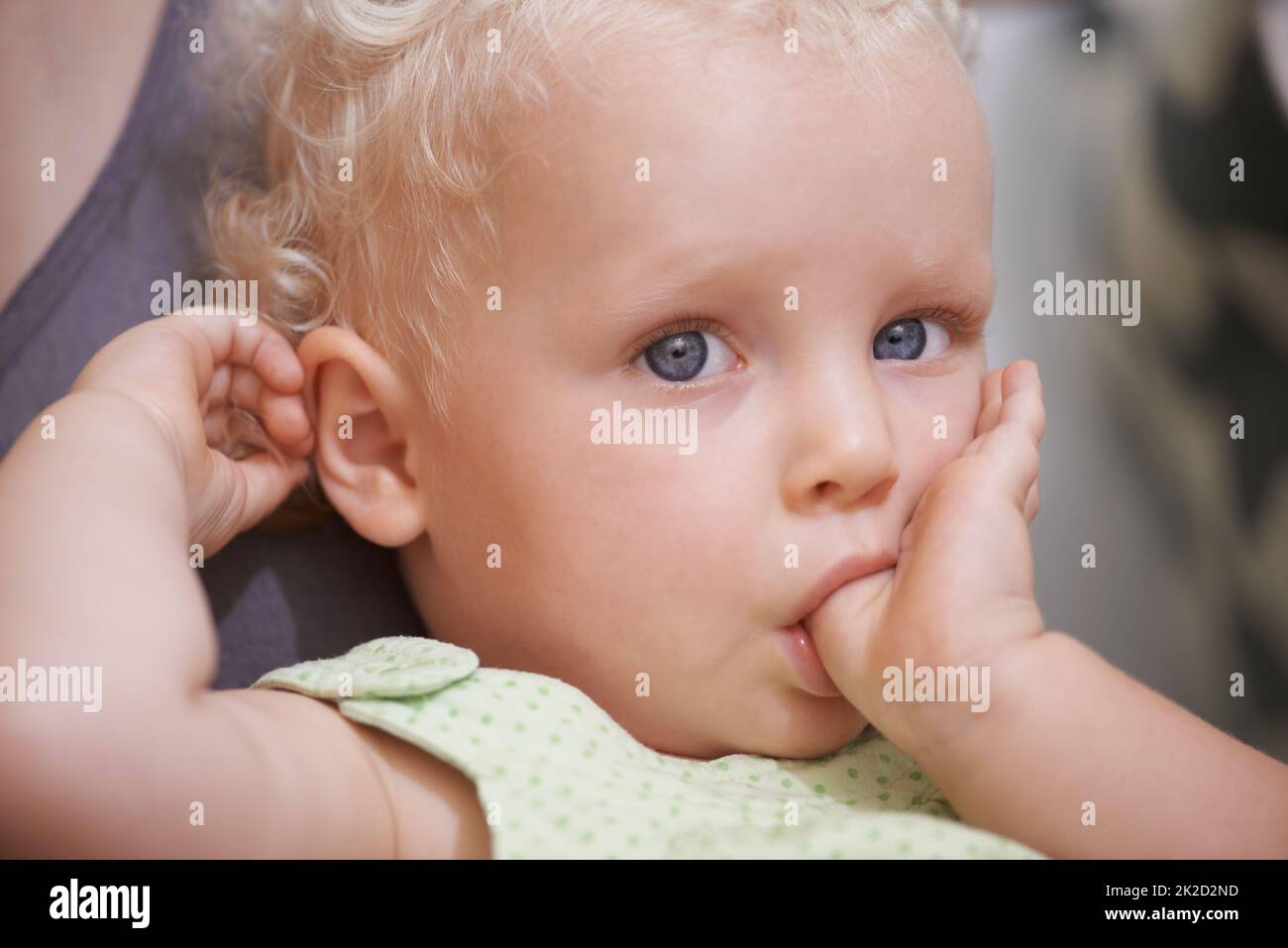 Elle est tout simplement adorable. Un jeune enfant mignon aux cheveux bouclés blonds. Banque D'Images